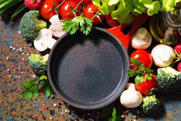 Empty cast iron skillet and fresh organic vegetables, top view c — Stock Photo, Image