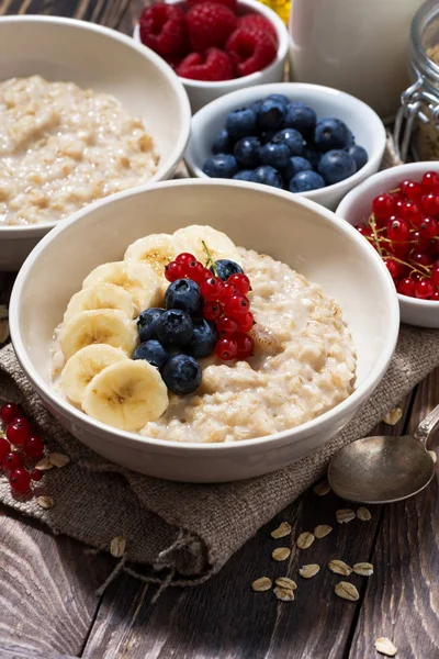 Farina d'avena fatta in casa con bacche su sfondo di legno, clo verticale — Foto Stock