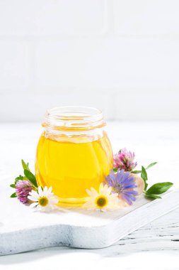 taze çiçek bal ve beyaz arka plan ile dikey kavanoz