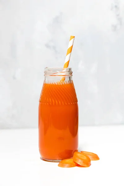 Fresh carrot juice in a bottle on white background, vertical — Stock Photo, Image