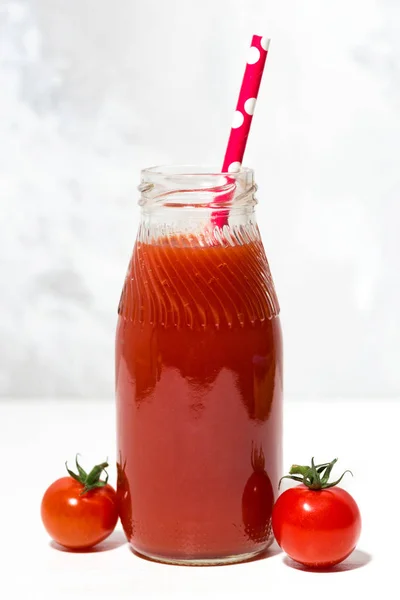 Fresh tomato juice in a bottle, vertical closeup — Stock Photo, Image