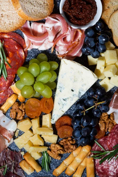 çeşitli peynirler, meyveler ve etler, dikey üst görünüm