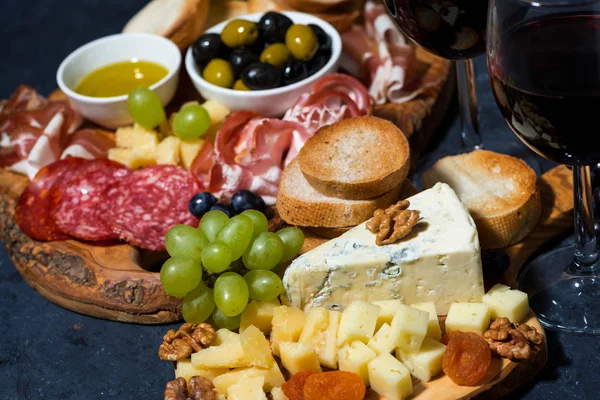 Bandeja de queso en una tabla de madera, pan, frutas y embutidos, cl — Foto de Stock