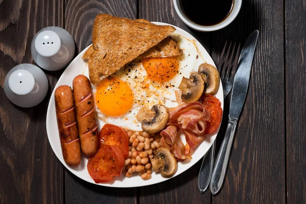 Spiegeleier mit Speck, Würstchen und Gemüse auf Holztisch, — Stockfoto