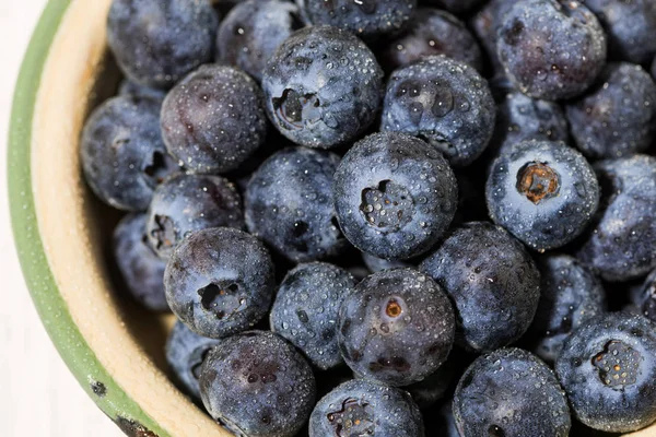 Färska saftiga blåbär i en skål på vit bakgrund, uppifrån — Stockfoto