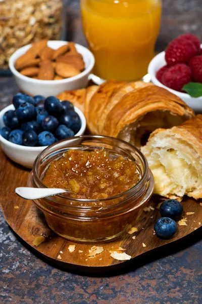 Croissant, orange jam and berries on a wooden board, vertical — Stock Photo, Image