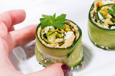 bir tabak üzerinde salatalık ve humus ile sağlıklı vejetaryen rulo, cl