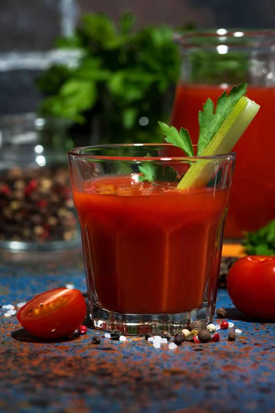 Färsk tomatjuice med salt och selleri på mörkt bord, vertikal — Stockfoto