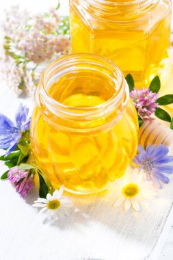 Beyaz ahşap tahta, dikey olarak taze çiçek bal kavanozlar 