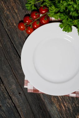 ahşap masa üzerinde beyaz tabak ve sebze ile masa ayarı