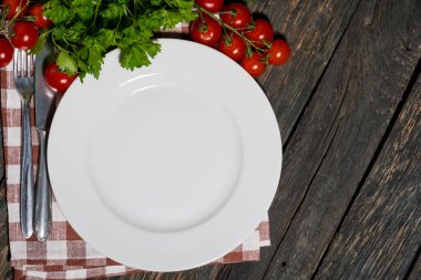 ahşap masa üzerinde beyaz tabak ve sebze ile masa ayarı