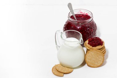beyaz masada süt, kurabiye ve tatlı kızılcık reçeli sürahi