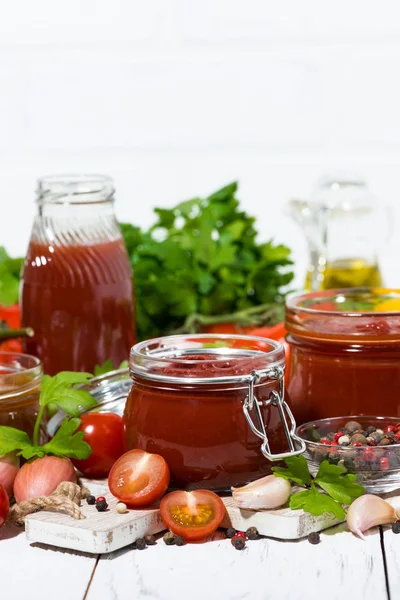 Molhos de tomate, massas e ingredientes frescos na mesa de madeira branca — Fotografia de Stock