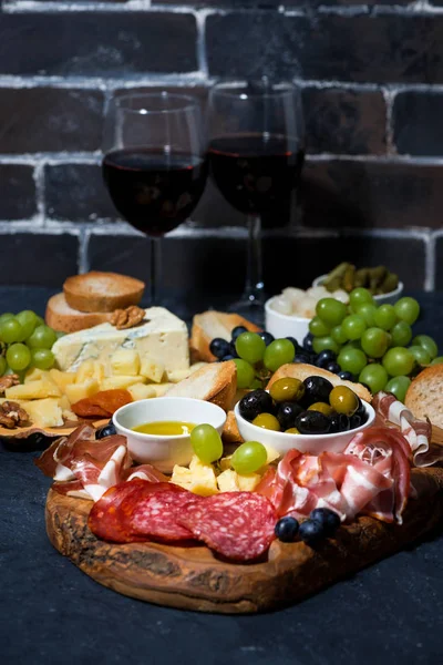 Dos copas de vino tinto y diversos quesos gourmet — Foto de Stock