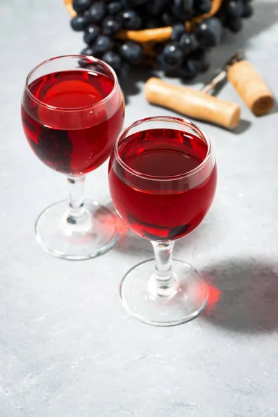 Два бокала красного вина на сером столе, вертикально — стоковое фото