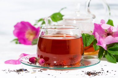 beyaz bir arka plan üzerinde bir cam fincan yabani gül ile kokulu çay