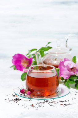 beyaz bir masa üzerinde bir cam fincan yabani gül ile kokulu çay