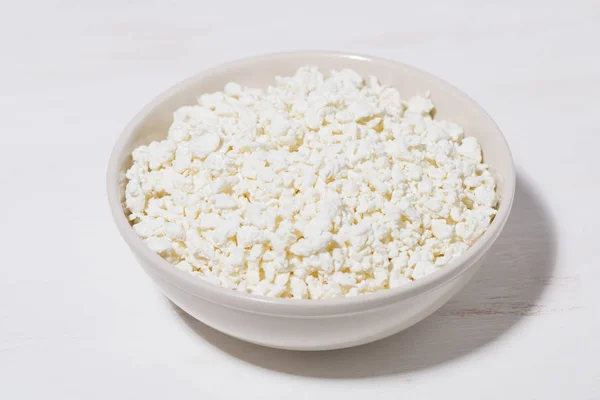Bowl of fresh farm cottage cheese on a white background — Stock Photo, Image