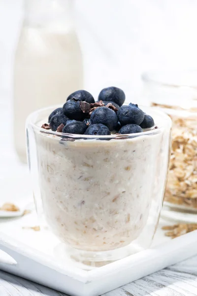 Bircher müsli med färska blåbär på vitt bord, vertikal — Stockfoto