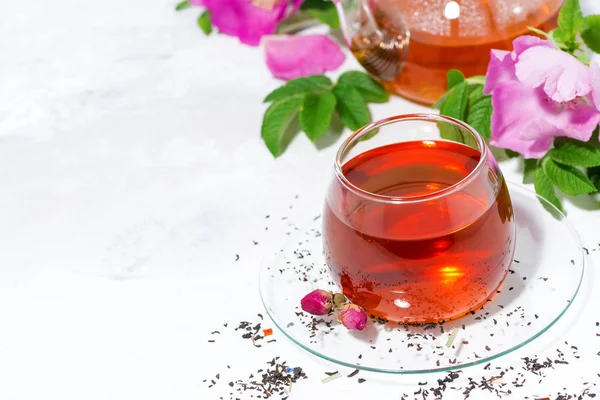 Pachnące herbaty z dzikiej róży w szklaną filiżankę na białym tle — Zdjęcie stockowe
