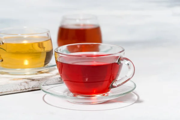 Асортимент чаю в скляних чашках на білому тлі, крупним планом — стокове фото