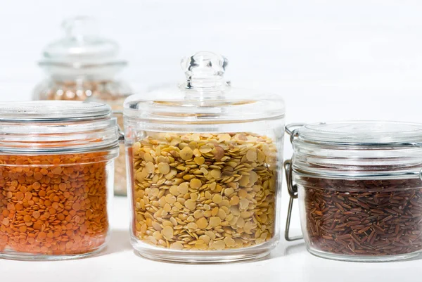 Surtido de diversos cereales y legumbres en frascos de vidrio — Foto de Stock