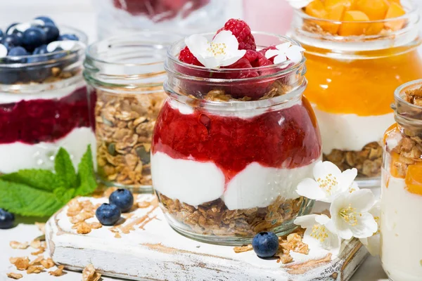 Desserts with muesli, fresh berries and fruit in jars, closeup — Stock Photo, Image