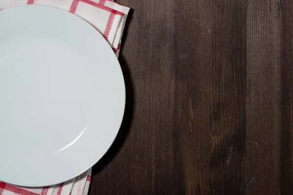 Plato vacío en una servilleta de cocina, fondo de madera para recetas —  Fotos de Stock