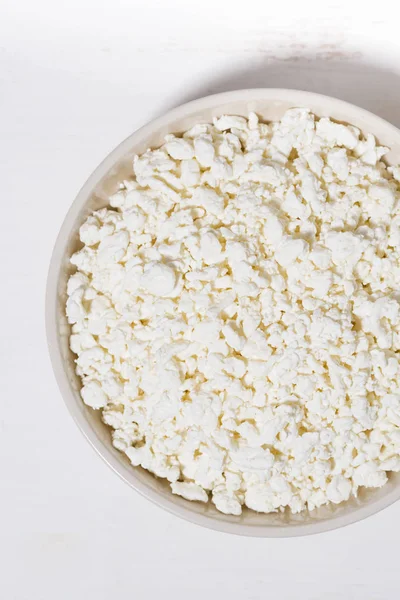 Bowl of fresh farm cottage cheese on a white background, closeup — Stock Photo, Image