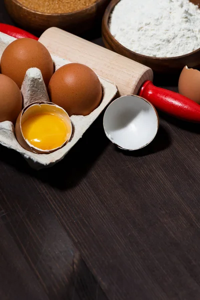 Verse verpakking van eieren en bakingrediënten, verticaal bovenaanzicht — Stockfoto