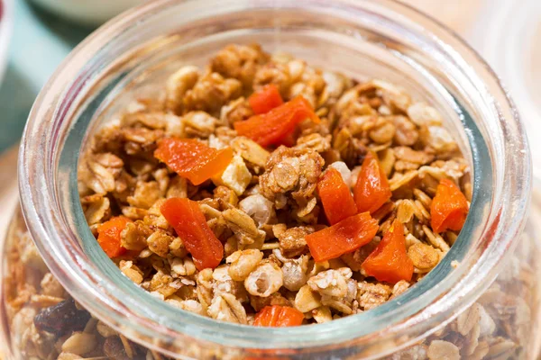 Zelfgemaakte granola met gedroogde abrikozen en noten in een pot, close-up — Stockfoto