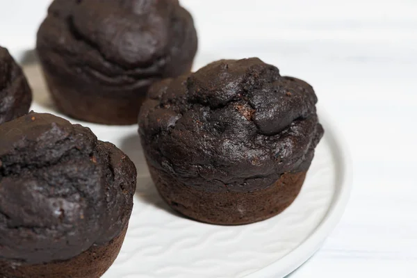 Deliciosas magdalenas de chocolate en un plato, vista superior —  Fotos de Stock