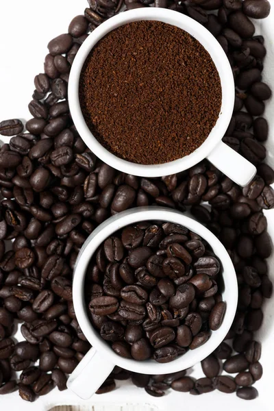 Tazas con café molido y granos de café, vista superior primer plano — Foto de Stock