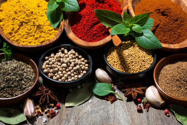 assortment of various spices and herbs on a wooden background