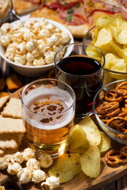 Bira ve çeşitli aperatifler, üst görünüm dikey.