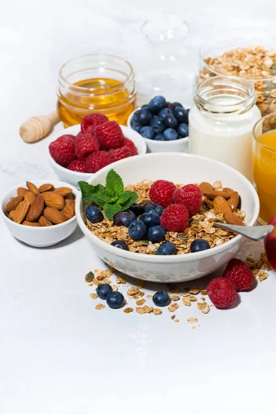 健康的な朝食 白を背景にしたグラノーラやフレッシュベリーやフルーツ垂直クローズアップ — ストック写真