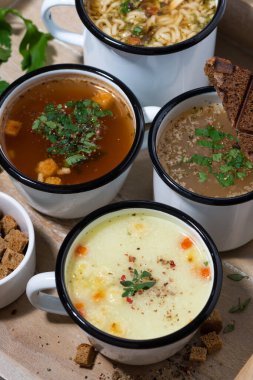 Bardaklarda sıcak çorba, ahşap tepside, üst manzara.