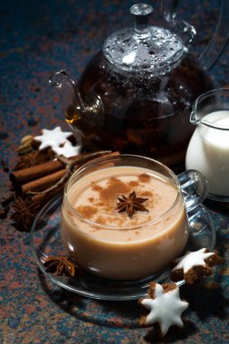 Baharatlı masala çayı ve kurabiyeler koyu arka planda, üst görünüm dikey