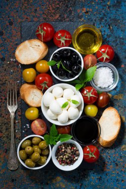 mozzarella, salata ve ekmek için malzemeler koyu arka planda, üst manzara