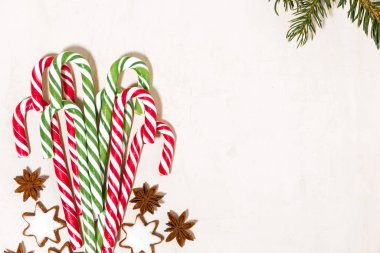 Beyaz arka planda çeşitli noel şekerleri ve kurabiye yıldızları, üst görünüm yatay