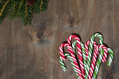 Yılbaşı şekeri çeşitleri ve gri arka planda köknar dalları, üst görünüm yakın plan