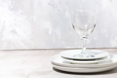 Bir yığın temiz beyaz tabak ve bir şarap kadehi. servis ögesi, yatay
