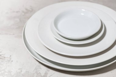 Beyaz arkaplanda beyaz plaka yığını, üst görünüm