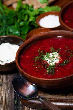 Ekşi kremalı geleneksel Rus çorbası ve ahşap arka planda dereotu, dikey yakın plan.