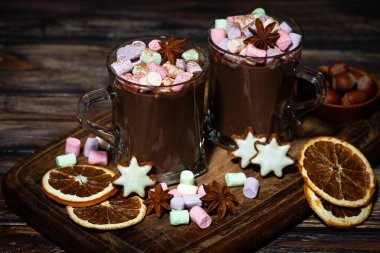 Tahta zemin üzerinde lokum olan iki fincan sıcak çikolata.