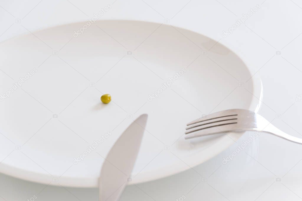 Empty dish with single pea vegetable meaning diet concept