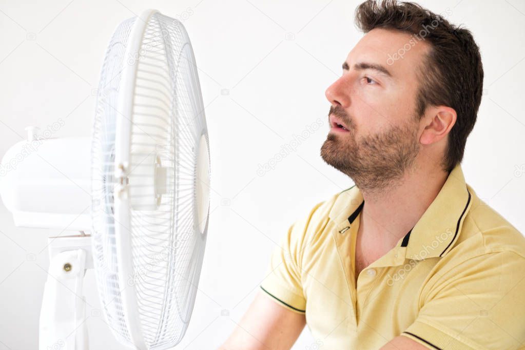 Young man suffering from summer heat and high humidity level