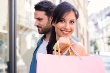 Mevsimlik satış sırasında kentin alışveriş torbaları ile genç mutlu çift