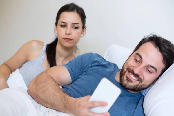 Jealous angry woman spying boyfriend and watching his mobile phone