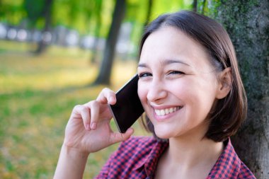 Akıllı telefon tutarak ve konuşan genç kadın portre